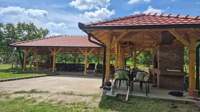 a wooden pavilion with chairs and tables in a park at Vinogradski konak Belgrade, Sopot,Kosmaj in Sopot