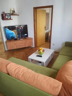 a living room with a couch and a tv and a table at Nika Apartment in Belgrade