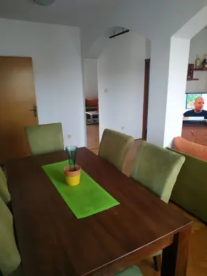 a wooden table with a green napkin on it at Nika Apartment in Belgrade