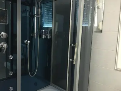 a shower in a bathroom with a glass shower stall at Apartmani Spasić in Smederevo
