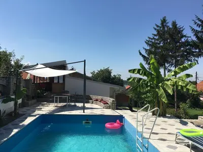 a pool with an umbrella and a pink ball in it at Apartmani Spasić in Smederevo