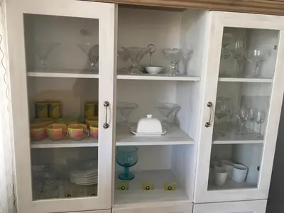 a white cabinet filled with dishes and glasses at Apartmani Spasić in Smederevo