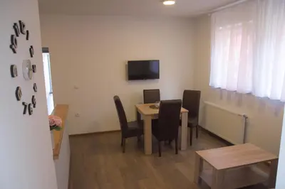 a dining room with a table and chairs and a television at MAGENTA Apartments in Belgrade