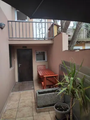 a patio with a wooden bench and a table at MAGENTA Apartments in Belgrade