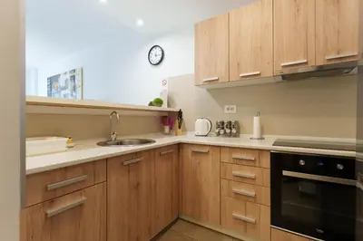 a kitchen with wooden cabinets and a sink and a clock at Zemunske Kapije in Belgrade
