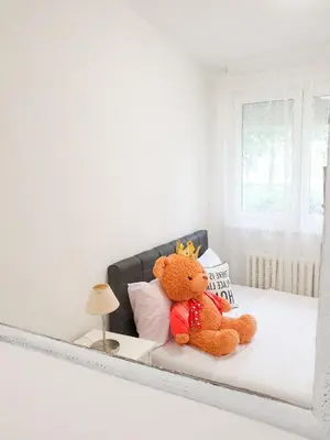 a teddy bear sitting on a bed in a room at Apartment Iskra in Belgrade