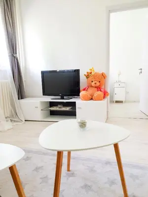 a teddy bear sitting on a chair in a living room at Apartment Iskra in Belgrade