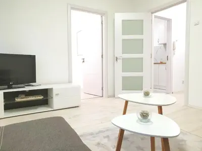 a living room with two tables and a tv at Apartment Iskra in Belgrade