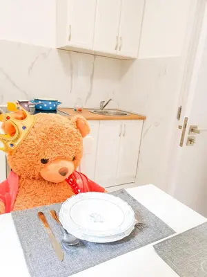 a teddy bear sitting at a table with a plate at Apartment Iskra in Belgrade