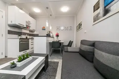 a kitchen and living room with a couch and a table at Gray Luxe in Belgrade