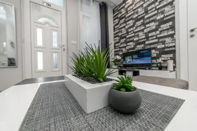 a living room with two potted plants on a table at Gray Luxe in Belgrade
