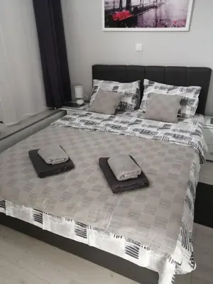 a large bed with two towels on top of it at Gray Luxe in Belgrade