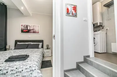 a small bedroom with a bed and a bathroom at Gray Luxe in Belgrade