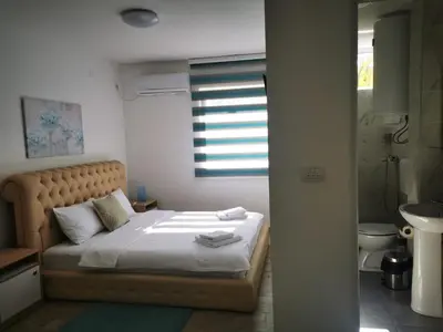 a bedroom with a bed and a bathroom with a window at Villa Boho Cherga in Belgrade