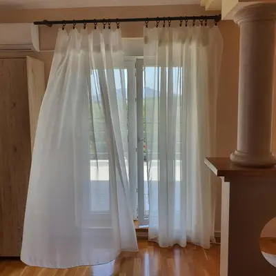 a white curtain in front of a glass door at Villa Boho Cherga in Belgrade