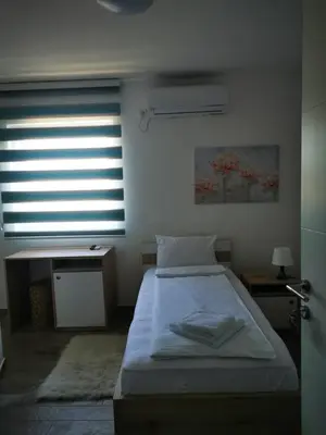 a bedroom with a bed and a window with blinds at Villa Boho Cherga in Belgrade