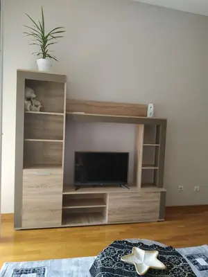 a large wooden entertainment center with a flat screen tv at SUMICE apartment in Belgrade
