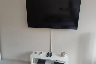 a flat screen tv hanging on a white wall at Apartman Mima in Belgrade