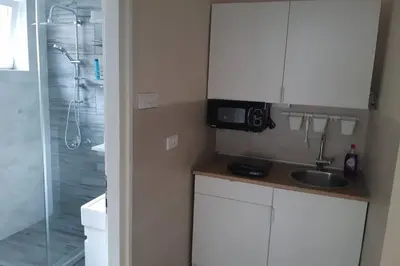 a small kitchen with a sink and a shower at Apartman Mima in Belgrade