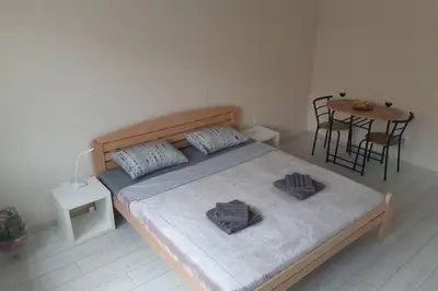 a bedroom with a bed and a table with chairs at Apartman Mima in Belgrade