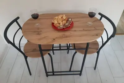 a wooden table with two wine glasses and a plate of food at Apartman Mima in Belgrade