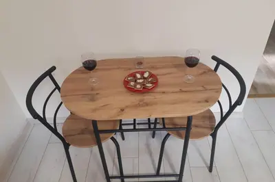 a wooden table with two glasses of wine on it at Apartman Mima in Belgrade