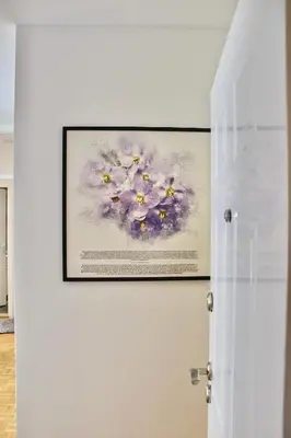 a painting of purple flowers on a wall at Ramonda Residences - New Belgrade in Belgrade