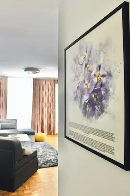 a painting of flowers hanging on a wall in a living room at Ramonda Residences - New Belgrade in Belgrade