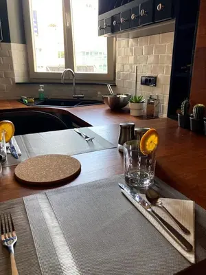 a kitchen with a wooden counter top with a table with a glass at Apartman Lola in Vračar (historical)