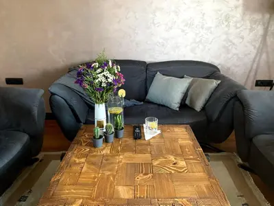 a living room with a couch and a wooden table with flowers at Apartman Lola in Vračar (historical)
