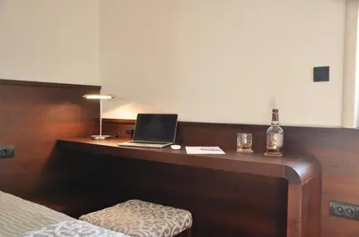 a desk with a laptop and a bottle of whiskey at Apartman Lola in Vračar (historical)