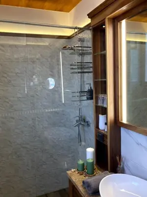 a bathroom with a glass shower with a sink at Apartman Lola in Vračar (historical)