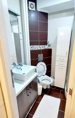 a bathroom with a white toilet and a sink at High White Apartments in Belgrade