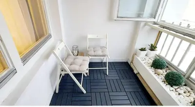a balcony with two chairs and two windows at High White Apartments in Belgrade