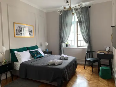 a bedroom with a bed and a desk and a window at Dragonfly Residence in Belgrade