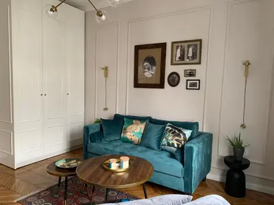 a living room with a blue couch and a table at Dragonfly Residence in Belgrade