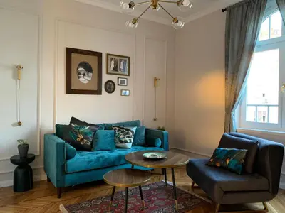 a living room with a blue couch and a table at Dragonfly Residence in Belgrade