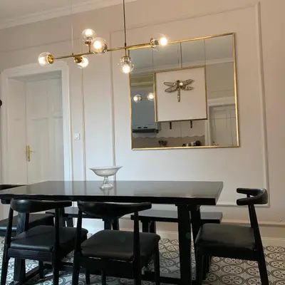 a dining room table with black chairs and a mirror at Dragonfly Residence in Belgrade