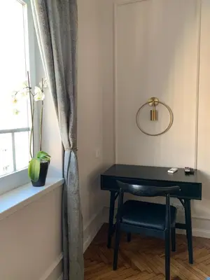 a black desk with a chair next to a window at Dragonfly Residence in Belgrade