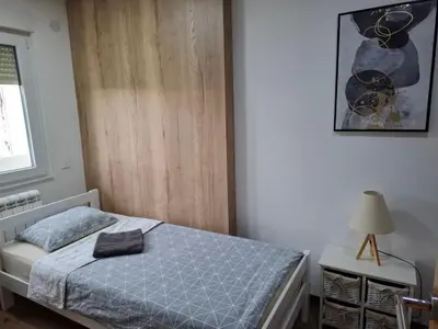 a bedroom with a bed and a picture on the wall at Serbian home, Gandijeva 162, free parking in Belgrade