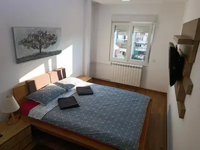 a small bedroom with a bed with a blue comforter at Serbian home, Gandijeva 162, free parking in Belgrade