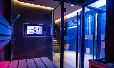 a room with a tv on a wall with glass at Marconio Wellness Private Pool & SPA - City Center in Belgrade