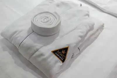 a white blanket with a white flower on a bed at Marconio Wellness Private Pool & SPA - City Center in Belgrade