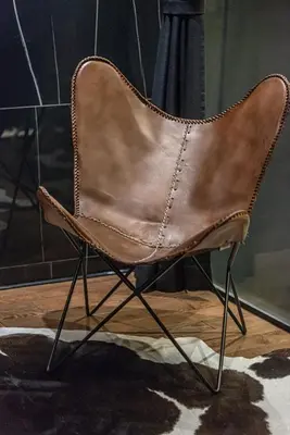a brown leather chair sitting on a wooden floor at Marconio Wellness Private Pool & SPA - City Center in Belgrade