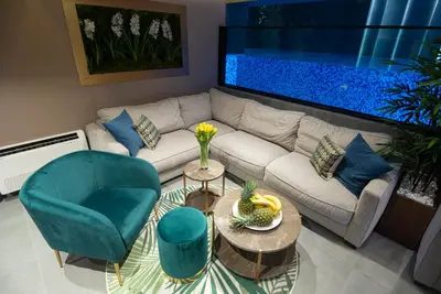 a living room with a couch and a fish tank at Marconio Wellness Private Pool & SPA - City Center in Belgrade