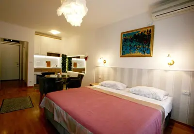 a bedroom with a bed and a dining room at Apartment Moonstone 1 in Belgrade