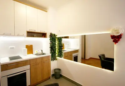 a kitchen with white cabinets and a sink and a counter at Apartment Moonstone 1 in Belgrade