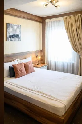 a bedroom with a large bed with a window at MV Monogram in Inđija