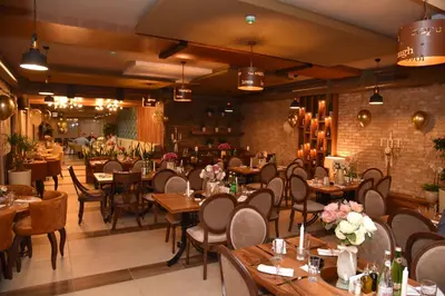 a restaurant with wooden tables and chairs and a brick wall at MV Monogram in Inđija