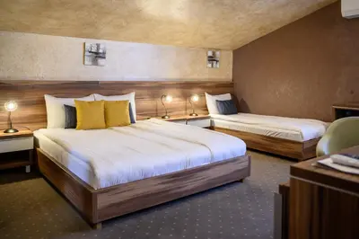 a hotel room with two beds and a chair at MV Monogram in Inđija